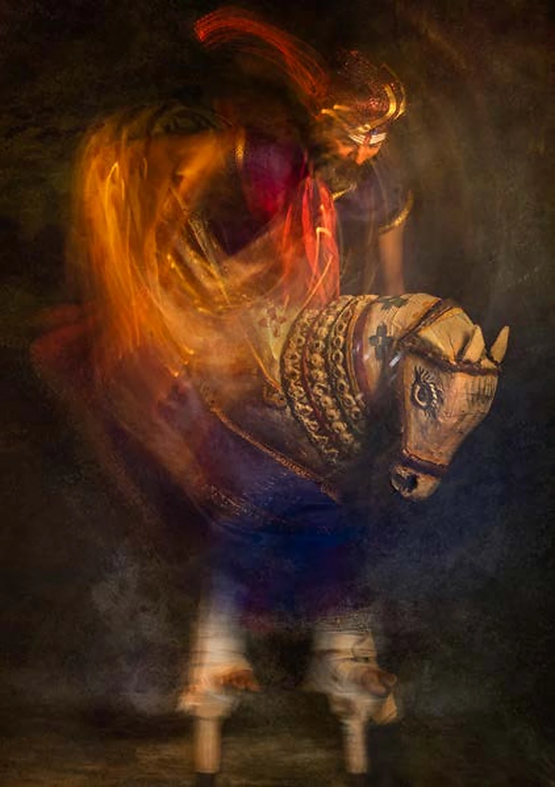 Long-exposure photograph of a Tamil folk performer and horse costume in motion