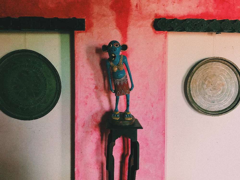 A carved figure against a pink wall, Tanzania