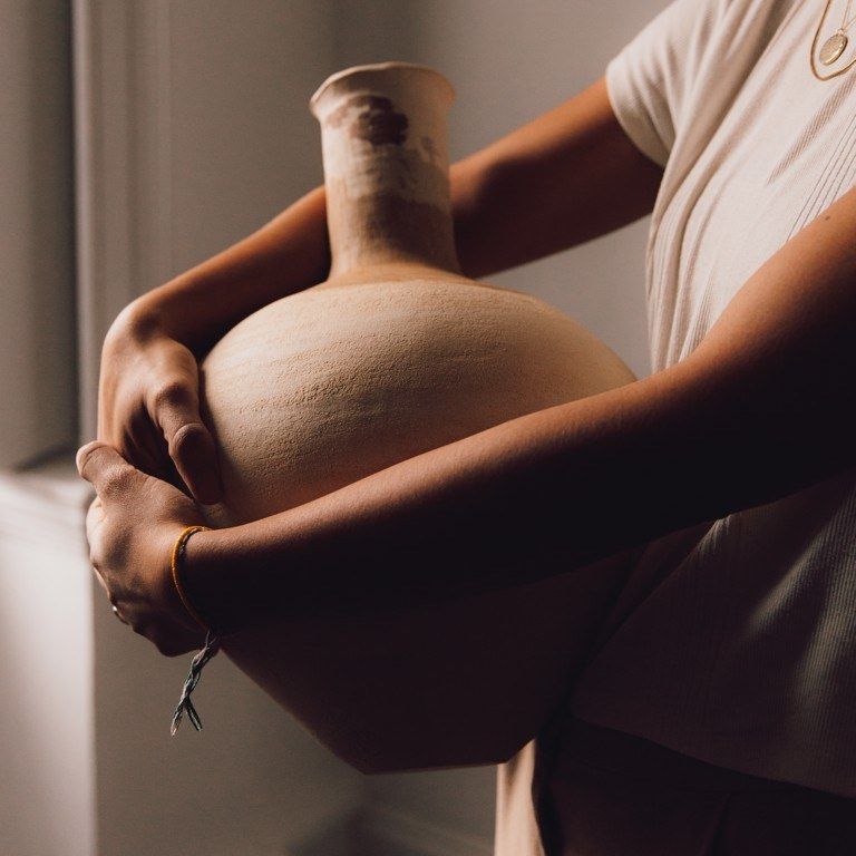 A large unglazed vessel held against the body
