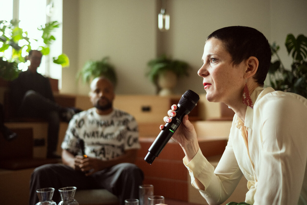 Catherine Hug in conversation with Marvin Kangsen listening in the background